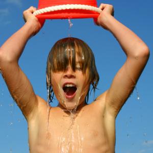 A child dumps ice water over his head. Image courtesy Suzanne Tucker/shutterstoc