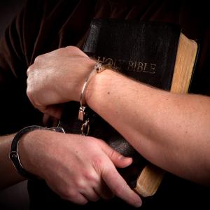 Prisoner clutch Bible, Steven Frame, Shutterstock.com