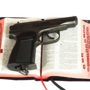 Religion and gun photo,  sagasan / Shutterstock.com