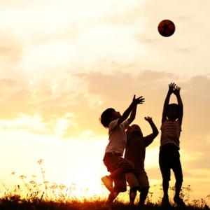 Children playing with a ball at sunset. Image courtesy Zurijeta/shutterstock.com