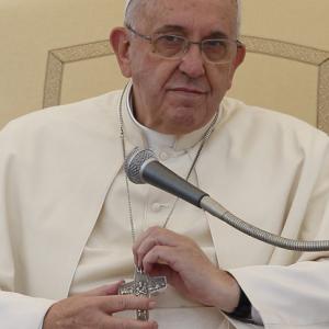 Pope Francis holds his pectoral cross.  Photo via Paul Haring / Catholic News Se