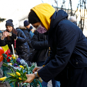 A woman places flowers outside the Ukrainian embassy in Moscow after Russia launched a massive military operation against Ukraine on Feb. 24, 2022.