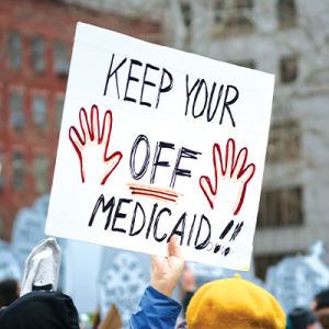 Poster saying "Keep Your Hands Off Medicaid!!" at a protest.