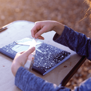 A child sits at a desk with a notebook.