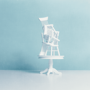 Illustration of white chairs piled haphazardly on top of a dining table