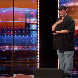 Richard Goodall putting his hand on his chest as he performs on the America's Got Talent stage.