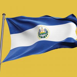 A picture of El Salvador's blue and white national flag, flying from a flag pole against a yellow backdrop.
