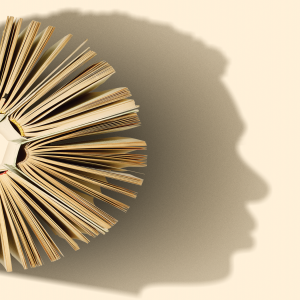 A semi-circle of open books casts the shadow of the profile of a human face