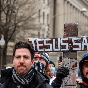 Trump supporters at the Jan. 6 Capitol riot hold a cross that says 'Jesus Saves'