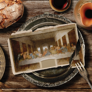 The image shows a table from a bird's-eye-view, with a loaf of bread, a pitcher, and a fish. In the middle there is a platter with an image of the Last Supper, being cut apart by a fork. 