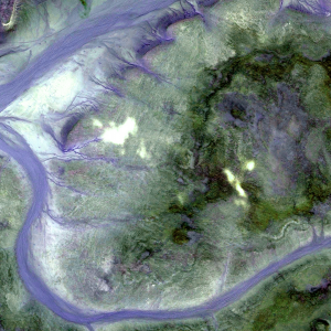 An aerial view of two rivers flowing around a green area of land
