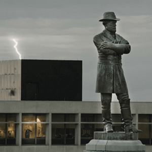 A confederate monument stands before a lightening storm