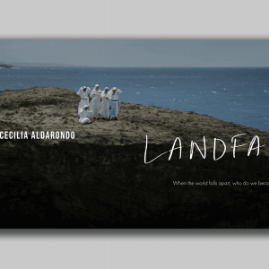 A group of people wearing white stand on the edge of the land where it meets the sea