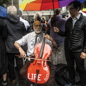 John Mark Rozendaal plays his cello in front of Citibank headquarters in New York City as part of summer-long protests by climate activists, dubbed the "Summer of Heat."