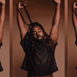 Mykal Kilgore stretches his arms to the sky with his locs wrapped around his hand