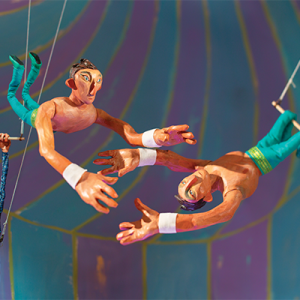 A painting featuring two members of the Flying Rodleighs flying in the air with Henri Nouwen holding onto a trapeze in the background.