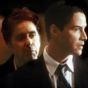 The image shows a scene from "The Devil's Advocate," where one white man is looking over the shoulder of another white man in a suit, who is looking out a window. 