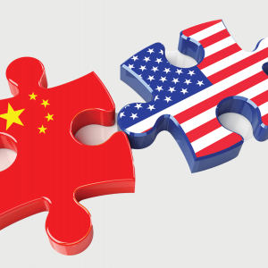 An illustration of two puzzle pieces, one bearing the flag of China while the other bears the flag of the United States. 