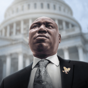 Ben Crump, dressed in a suit, looks up and away from the camera. The U.S. Capitol is in the background. 