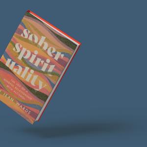 The cover for the book ‘Sober Spirituality’ features the title in block white text among layered thin waves of yellow, pink, green, and blue. The book is floating at an angle against a steel blue backdrop.
