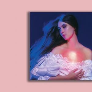 The cover for the music album ‘And in the Darkness, Hearts Aglow’ by Weyes Blood. The artist, Natalie Mering, has long hair and looks to the side. She wears a low-cut dress with her upper chest exposed. A warm light glows from within where her heart is.