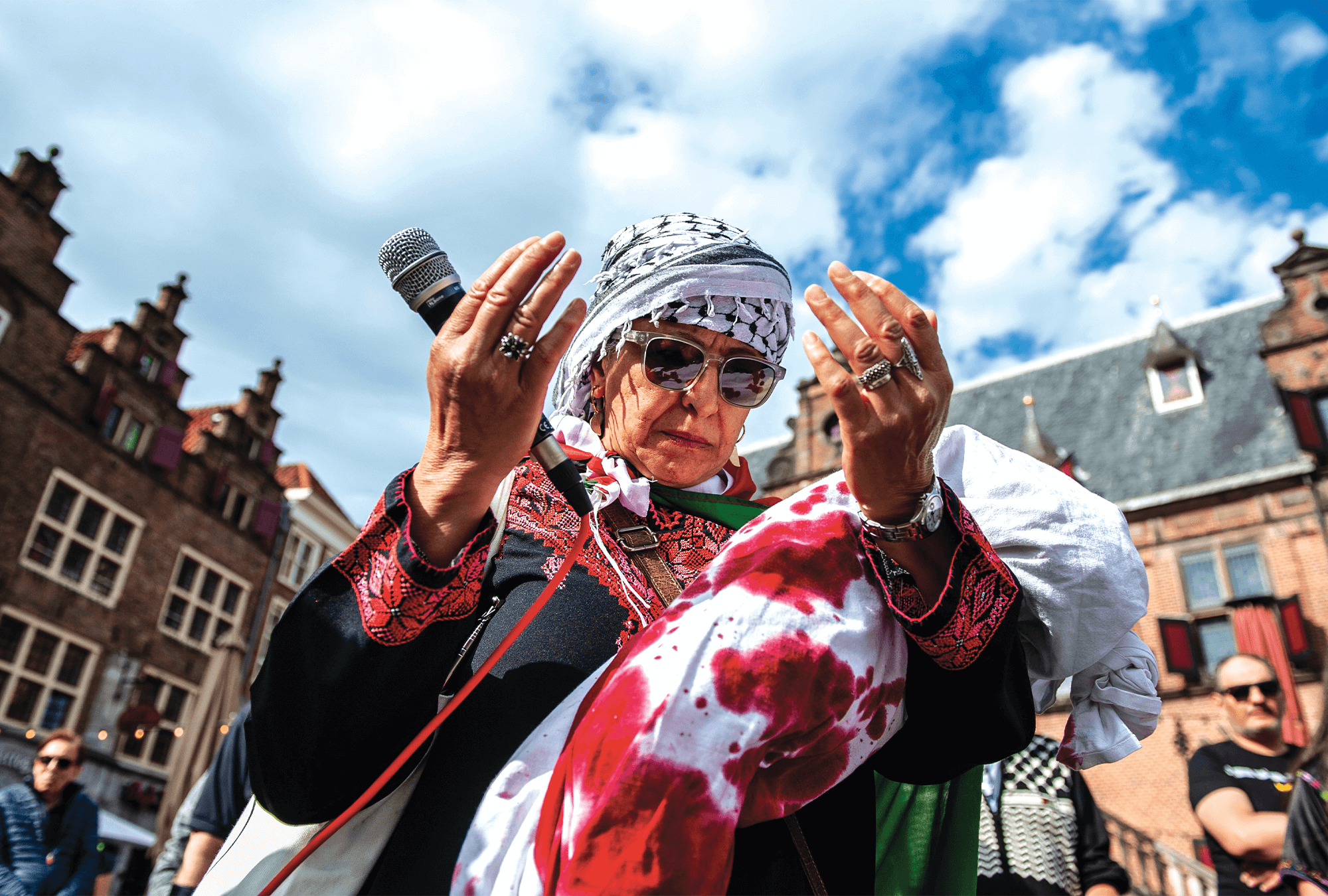 A demonstrator holding a doll wrapped in red-stained white sheets prays during a silent march for the children of Gaza in Nijmegen, Netherlands.