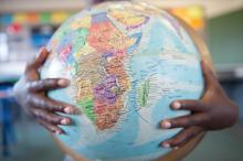 Boys hands hugging globe in classroom / Getty Images Boys hands hugging globe in classroom / Getty Images