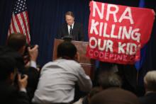 A demonstrator from CodePink holds up a banner as the NRA's Wayne LaPierre delivers remarks. Chip Somodevilla/Getty Images Chip Somodevilla/Getty Images
