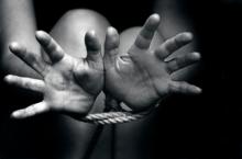Hands tied with rope. Photo courtesy of ChameleonsEye via Shutterstock