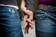 A young couple holds hands. Photo courtesy Peter Bernik/shutterstock.com