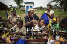 Sister Angélique Namaika (standing, in black), assists women with making clothing. Via RNS. Photo by Brian Sokol/courtesy UNHCR