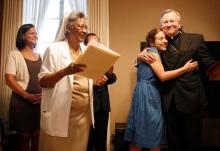 Paige LaCour, second from right, hugs Archbishop Gregory Aymond. RNS photo: Rusty Costanza / The Times-Picayune RNS photo by Rusty Costanza / The Times-Picayune