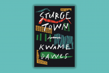The image is of the book called Sturge Town which is a poetry collection. The book is a dark gray with shapes in red, blue, green, and yellow