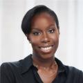 The image shows a Black woman wearing a black shirt and smiling