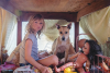 Scene from Don’t Let’s Go to the Dogs Tonight with a child sitting next to their dog and a doll.