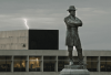 A confederate monument stands before a lightening storm