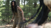 A Comanche woman stands in a combat-ready pose with a tomahawk against an assailant in the film 'Prey.'